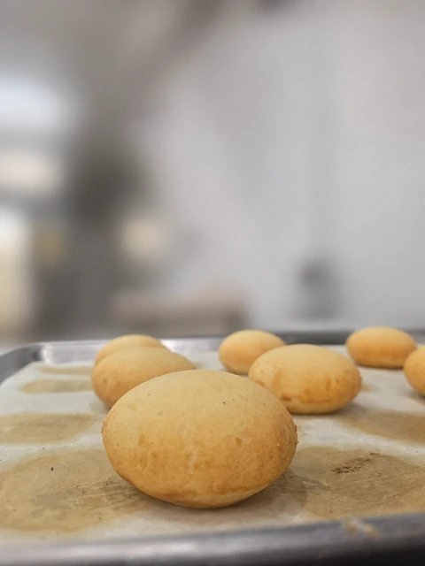 Round pandebono breads on a baking tray
